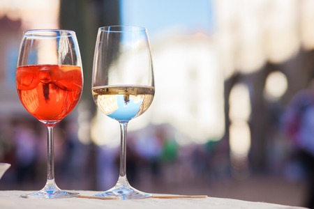 Chilled aperol spritz and prosesso glasses over Padova streets backgroundの写真素材