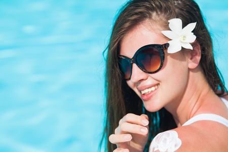 young woman applying sun cream uv protection