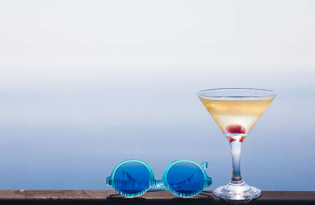 glass of martini over the sea backgroundの写真素材
