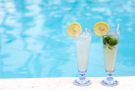 Two tropical cocktails near swimming poolの写真素材