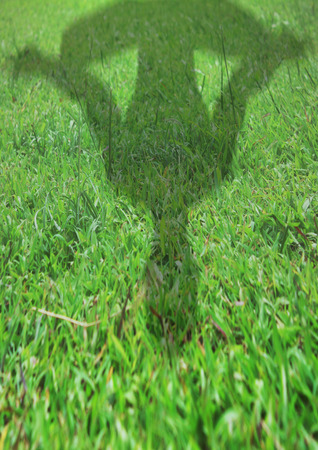 Shadow of a man figure meditating on the grassの写真素材
