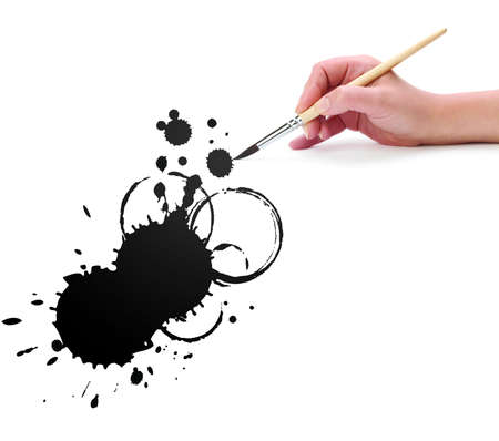 hand with brush and abstract ink blot の写真素材