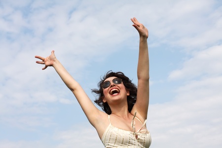 Happy woman with open hands under sky の写真素材