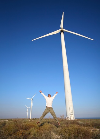 man and wind turbines under blue sky の写真素材