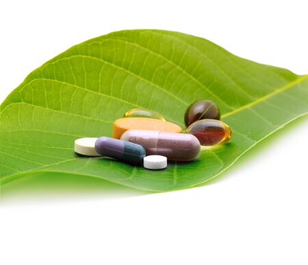 vitamins, tablets and pills on green leafの写真素材