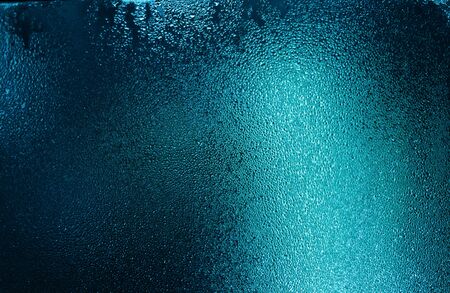 Blue water drops on wet glass with highlightsの写真素材