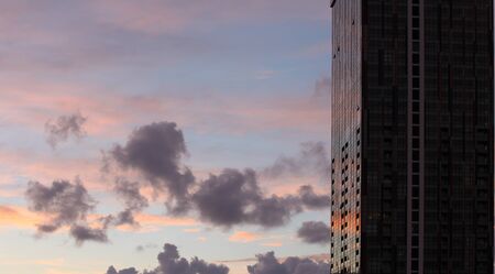 Dramatic evening sky with clouds.. Glass window architecture build background.