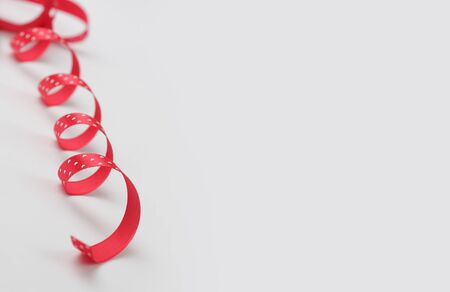 red silk ribbon with color dots on white backgroundの写真素材