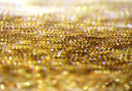 Gold (bronze) glitter shine dots confetti. Abstract light blink sparkle defocus backgound.の写真素材
