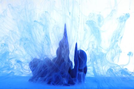 Abstract blue smoke on white background.  Acrylic colors in water. Ink blot. の写真素材