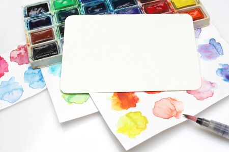 Box with watercolors, brush and palette on a light gray background. Paper texture empty card for messenger.の写真素材