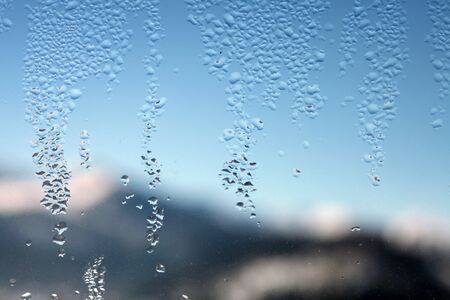 Water drop on glass. Window with blur winter landscape.の写真素材