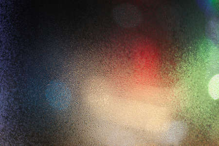 Water drops on wet window glass with city lights.の写真素材
