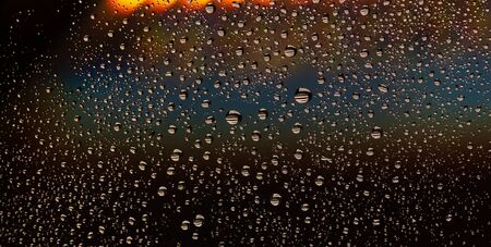 texture of large and small drops of water on a matte surface with color shadesの写真素材