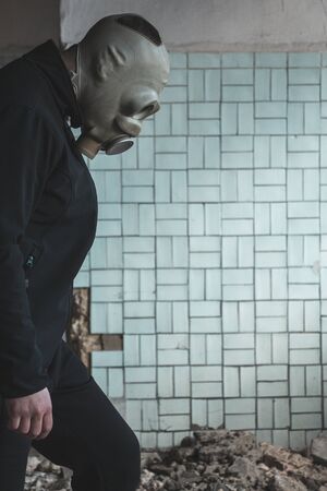 man in a gas mask on a background of a wall and a corridorの写真素材