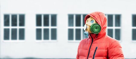 man in a gas mask and a hood on the background of windowsの写真素材