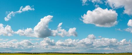 white clouds in broad daylight over a field