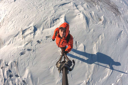 A guy with a briefcase behind his back against the background of a snowy horizon