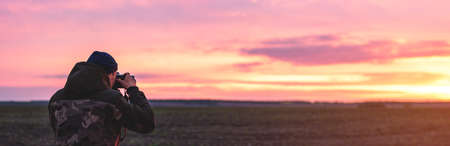 The photographer on the sunset shooting sunset landscape. Travel nature photography.の写真素材