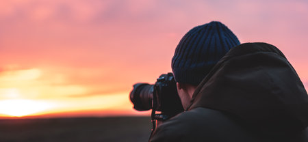 The photographer on the sunset shooting sunset landscape. Travel nature photography.の写真素材