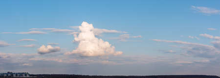 Air clouds in the blue sky. Nature background. Sunset sun. Warm evening. Sunset over the valley and slope. The rays of the sun through the cloud.の写真素材