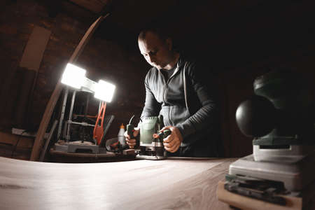 Carpenter with hand electric router machine at workの写真素材