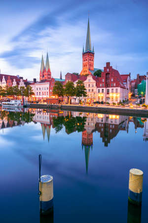 Lubeck, Germany. Cityscape image of riverside Lubeck  with reflection of the city in Trave River at sunset.の写真素材