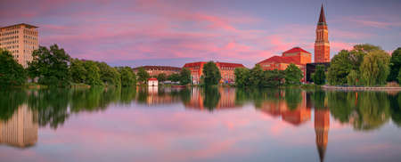 Kiel, Germany. Panoramic cityscape image of downtown Kiel, Germany with Town Hall, Opera House and reflection of the skyline in Small Kiel at sunset.の写真素材