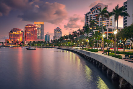 West Palm Beach, Florida, USA. Skyline of West Palm Beach, Florida, at dusk. Tall buildings with reflective glass facades line the waterfront, casting colorful reflections.の写真素材