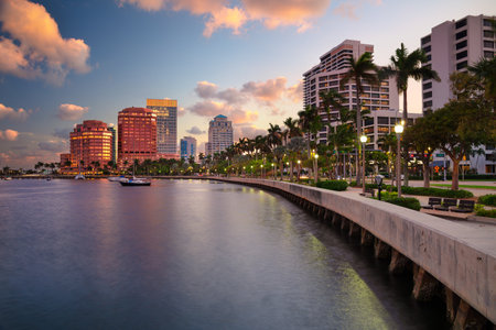 West Palm Beach, Florida, USA. Skyline of West Palm Beach, Florida, at dusk. Tall buildings with reflective glass facades line the waterfront, casting colorful reflections on the wの写真素材