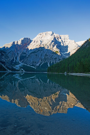 A dolomite peak is reflected in the morning light in the Pragser Wildsee in the Fanes-Sennes-Prags Nature Parkの写真素材