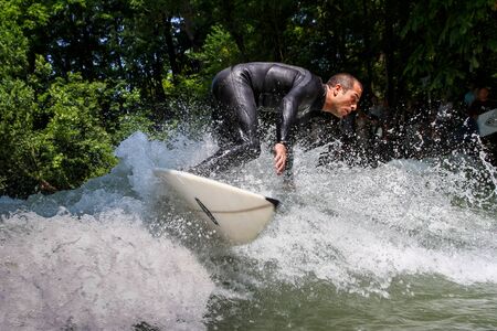 Munich, Germany - July 13, 2019: Surfer in the city river, Munich is famous for people surfing in...