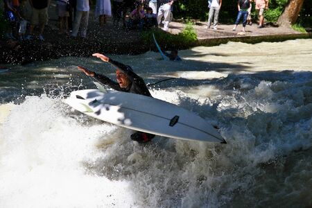 Munich, Germany - July 13, 2019: Surfer in the city river, Munich is famous for people surfing in...