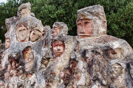 Faces engraved on the rock. Enchanted Castle of Sciacca, open-air museum in Agrigento, Sicily in...