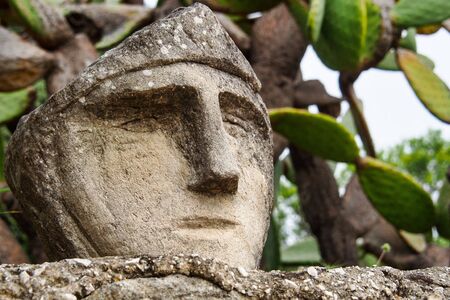 Faces engraved on the rock. Enchanted Castle of Sciacca, open-air museum in Agrigento, Sicily in Italyの写真素材