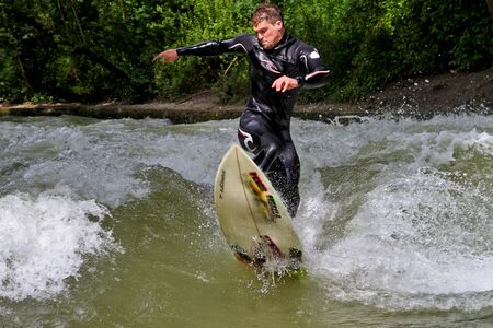Munich, Germany - July 13, 2019: Surfer in the city river, Munich is famous for people surfing in...