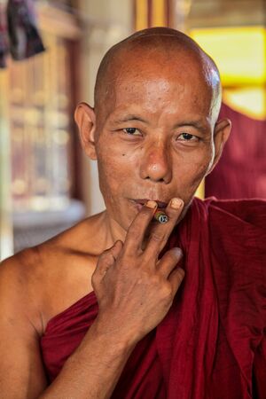 Mawlamyine, Myanmar - Nov 05, 2019: Smoking Monk at Monastery of Kyaung Seindon Mibaya at Mawlamyine...