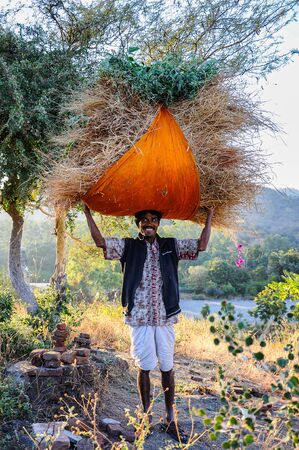Ranakpur, India - Jan 02, 2020: Indian man carries hay on his head.のeditorial素材