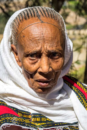 Wukro Cherkos, Ethiopia - Feb 11, 2020: Old woman at the rocky church of Wukro Cherkos in Ethiopia, Africaのeditorial素材