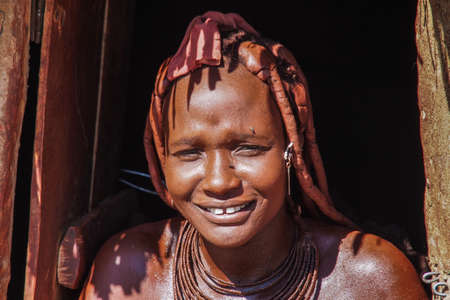 Opuwo, Namibia - Jul 07, 2019: Unidentified Himba woman with the typical necklace and hairstyle in himba tribe villageのeditorial素材