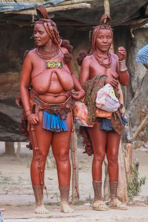 Opuwo, Namibia - Jul 06, 2019: Unidentified Himba women with the typical necklace and hairstyle in...