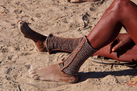Opuwo, Namibia - Jul 07, 2019: Unidentified Himba women with the typical foot jewelry in a himba...