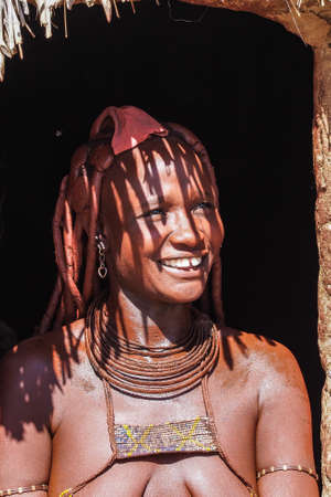 Opuwo, Namibia - Jul 07, 2019: Unidentified Himba woman with the typical necklace and hairstyle in himba tribe villageのeditorial素材