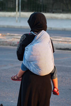 Fes, Morocco - Oct 15, 2019: Woman with child at Bab Boujloud, or the Blue Gate to old Medina Fez El Bali.のeditorial素材
