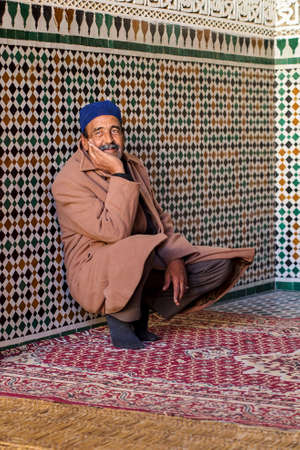 Meknes, Morocco - Oct 16, 2019: Man sitting at Mausoleum of Moulay Ismail in Meknes in Morocco....