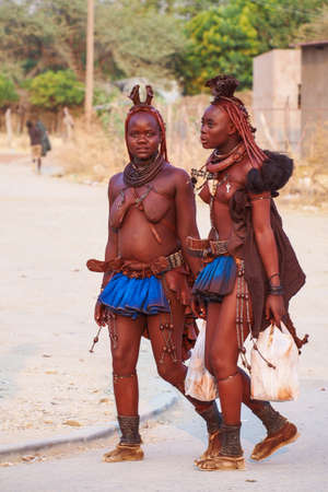 Opuwo, Namibia - Jul 06, 2019: Unidentified Himba women with the typical necklace and hairstyle in the streets of Opuwoのeditorial素材