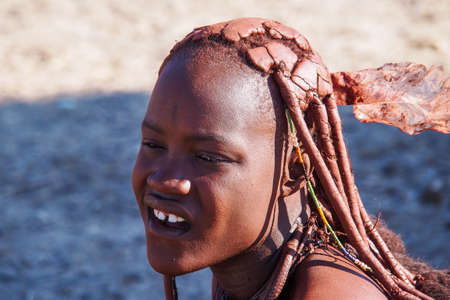 Opuwo, Namibia - Jul 07, 2019: Unidentified Himba woman with the typical necklace and hairstyle in himba tribe villageのeditorial素材