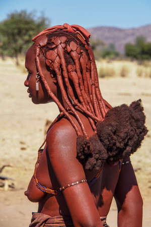 Opuwo, Namibia - Jul 07, 2019: Unidentified Himba woman with the typical necklace and hairstyle in...