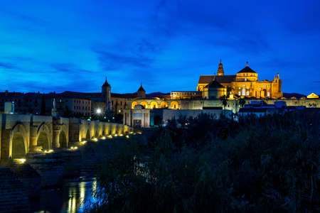 Cordoba, Spain - October 31, 2019: Mezquita-Catedral and Puente Romano - Mosque-Cathedral and the Roman Bridge in Cordoba, Andalusia, Spain at nightのeditorial素材
