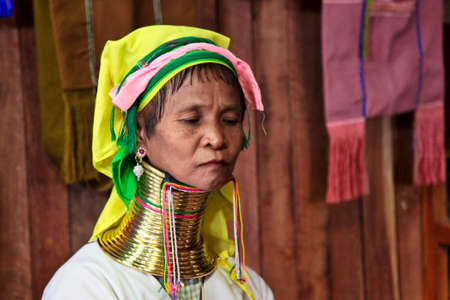 Inle Lake, Myanmar - Nov 09, 2019: Woman of Padaung tribe, Karen long-necked tribe with traditional metal rings around her neck weaving textile scarfのeditorial素材